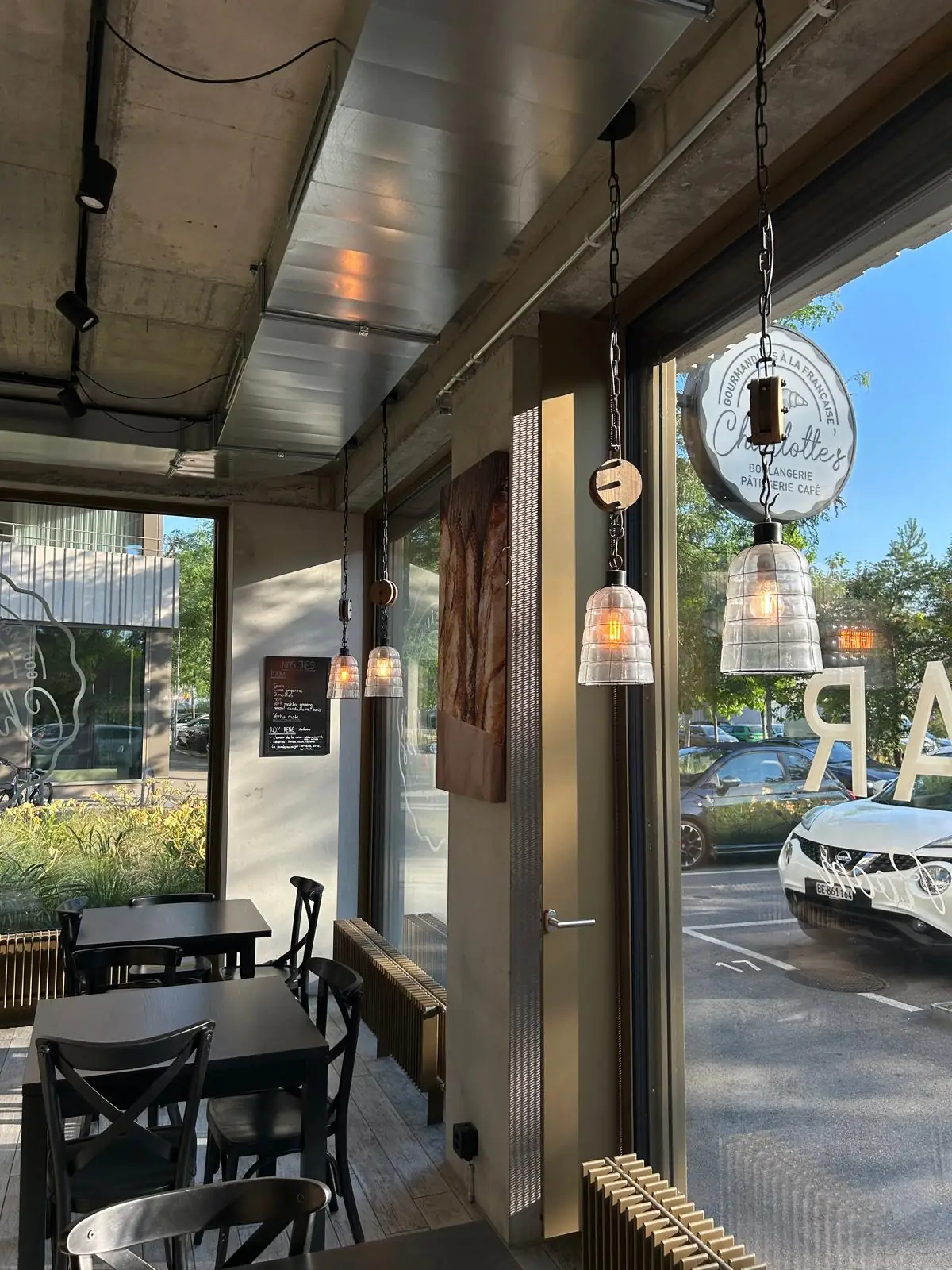 Intérieur du salon vu depuis la porte, suspensions et tables